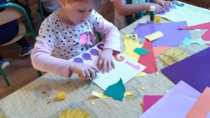 dzieci przyklejają kolorowy papier na kartkę