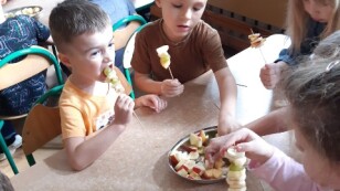 dzieci samodzielnie nakładają owoce na patyczek