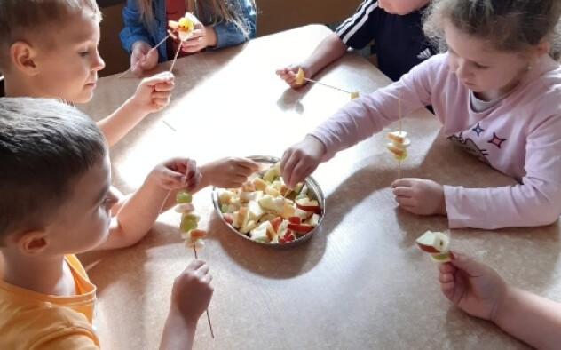 dzieci wykonują szaszłyki owocowe
