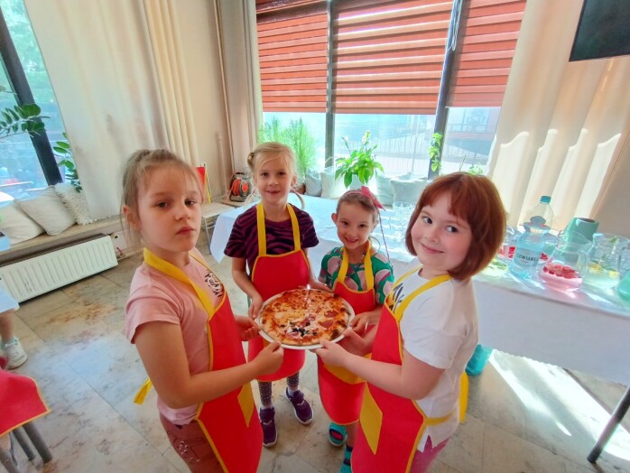 dzieci trzymają pizzę