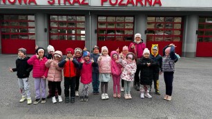 Dzieci stoją przed budynkiem Straży Pożarnej